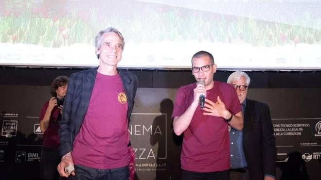 Jeremy Irons con la maglietta del cinema America per esprimere solidarietà ai ragazzi picchiati (Ansa)