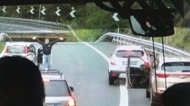 Quest'immagine sta facendo il giro del web: un uomo si sbraccia per fermare le auto in arrivo sul ciglio del crollo