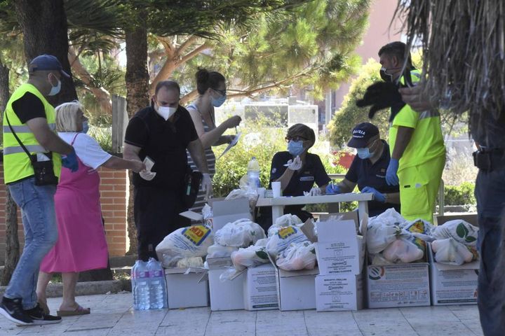 Consegna di pacchi alla gente bloccata in zona rossa (Ansa)