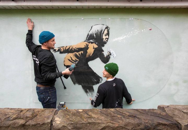 Banksy, Fred Loosmore and Sam Hun cercano di proteggere l'opera comparsa a Bristol