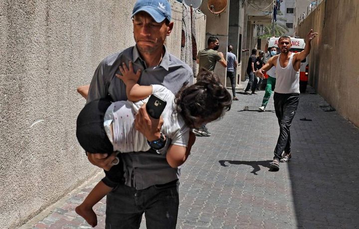Civili lasciano gli edifici bombardati a Gaza (Ansa)