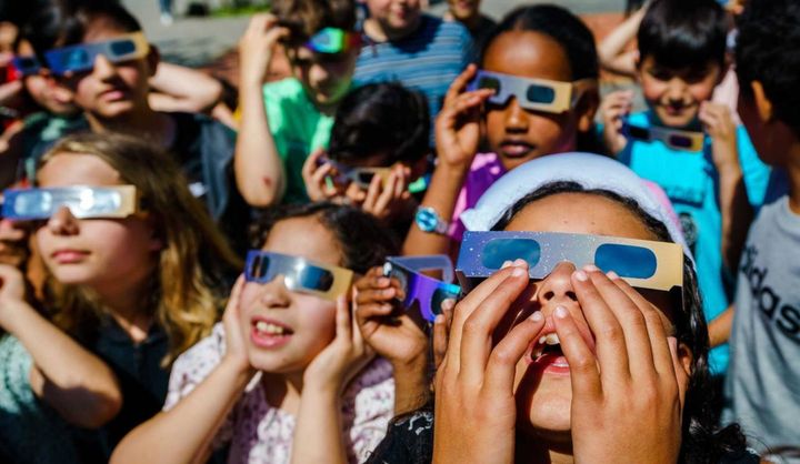 Bambini in Olanda guardano l'eclissi con gli occhiali protettivi (Ansa)
