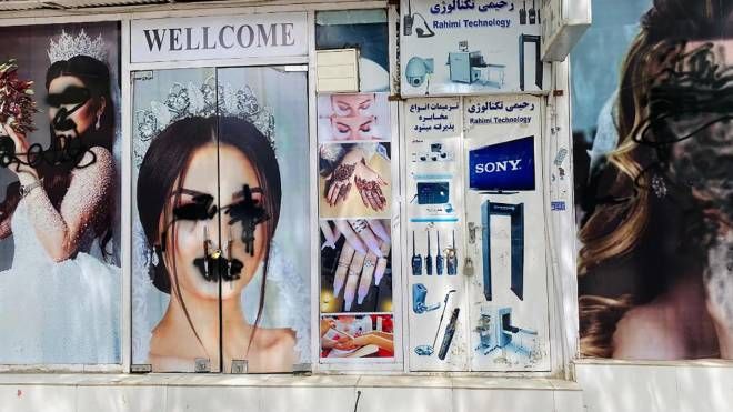 Spray nero sui poster delle modelle affissi sulle vetrine di un salone di bellezza a Kabul (Ansa)
