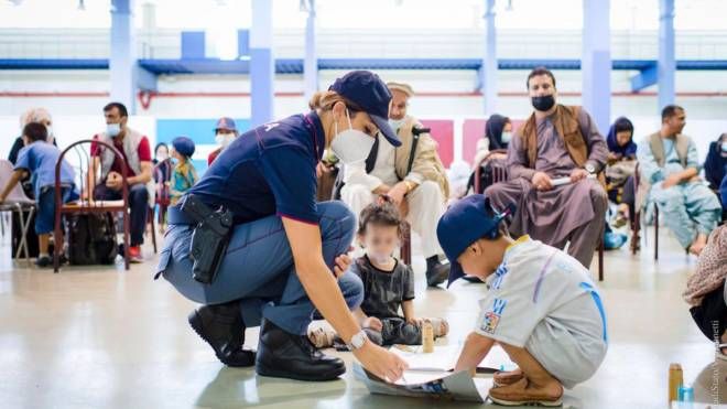 La Polizia di Stato a Fiumicino intrattiene i tanti bambini costretti a lasciare l'Afghanistan (Ansa)