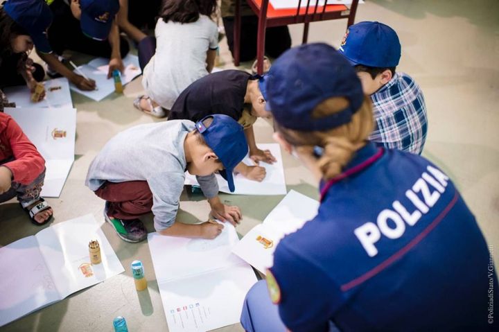 La Polizia di Stato a Fiumicino intrattiene i tanti bambini costretti a lasciare l'Afghanistan (Ansa)