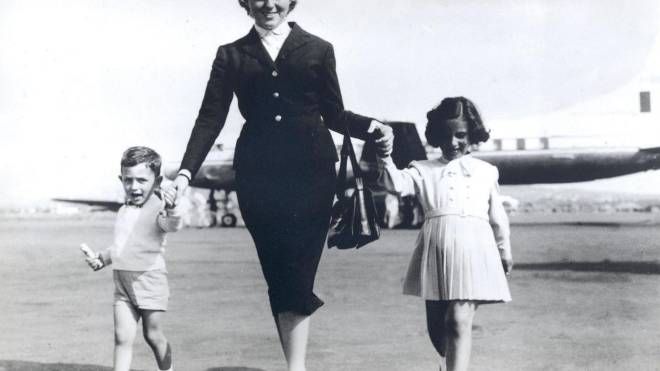 Una hostess tiene per mano due piccoli passeggeri in una foto diffusa dall'Alitalia in occasione della celebrazione di 70 anni dal primo volo, partito il 5 maggio 1947