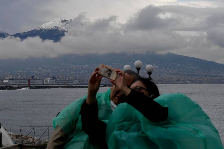 Due turisti ammirano lo spettacolo del Vesuvio imbiancato