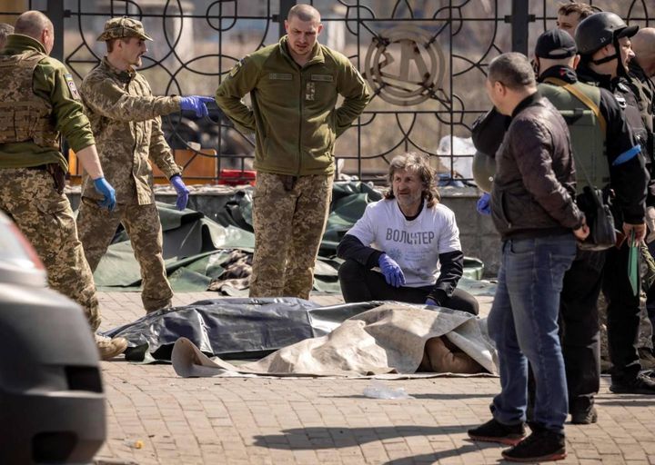 Soldati ucraini spostano cadaveri dopo l'attacco, sono almeno 35 le vittime (ANSA)