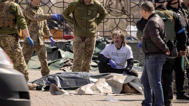 Soldati ucraini spostano cadaveri dopo l'attacco, sono almeno 35 le vittime (ANSA)
