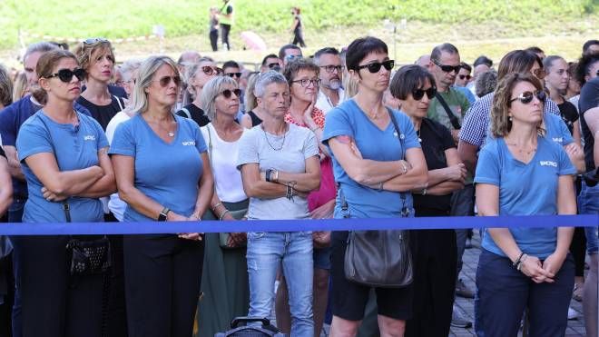 Dipendenti di Luxottica in maglia blu seguono dal maxischermo il funerale 
del presidente Leonardo Del 
Vecchio  