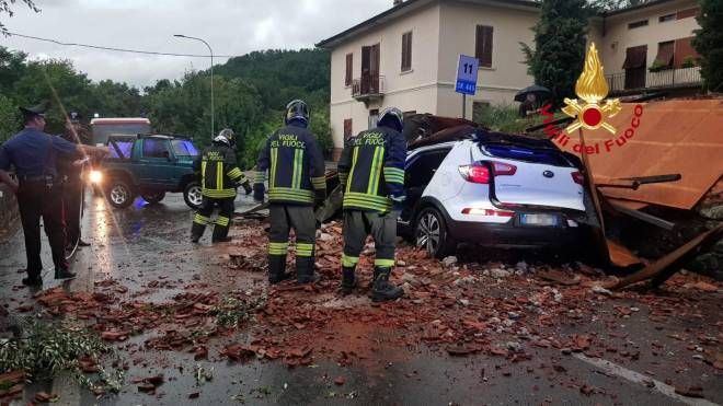 I vigili del fuoco intervengono per rimuovere un tetto volato via da una abitazione che ha centrato un auto a Fornaci di Barga (Lucca)