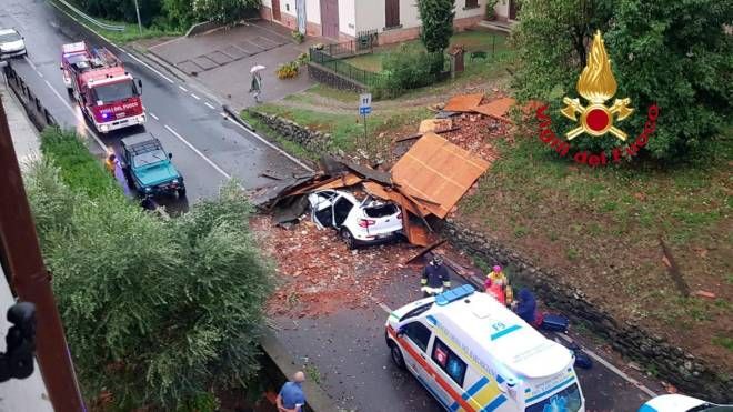 I vigili del fuoco intervengono per rimuovere un tetto volato via da una abitazione che ha centrato un auto a Fornaci di Barga (Lucca)