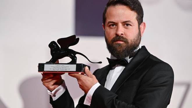 Il regista iraniano Houman Seyyedi con il premio Orizzonti (Ansa)