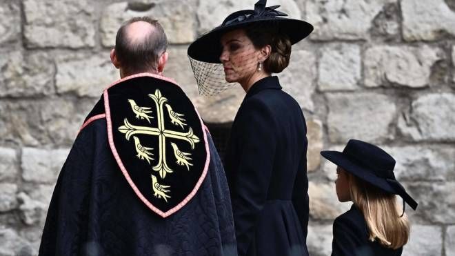 Charlotte entra nella cattedrale di Westminster tendo la madre Kate per mano (Foto AFP/ Ansa)
