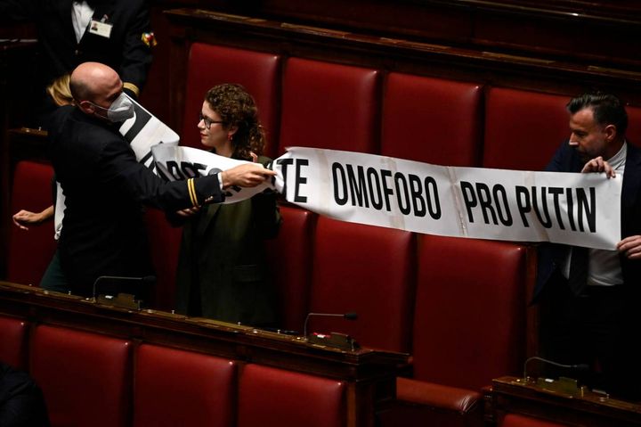 I commessi parlamentari tolgono lo striscione esposto dai deputati del Pd contro Lorenzo Fontana (Ansa)