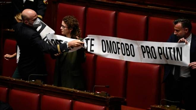 I commessi parlamentari tolgono lo striscione esposto dai deputati del Pd contro Lorenzo Fontana (Ansa)