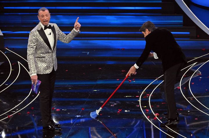 Amadeus e Gianni Morandi mentre spazza il palco di Sanremo (Ansa)