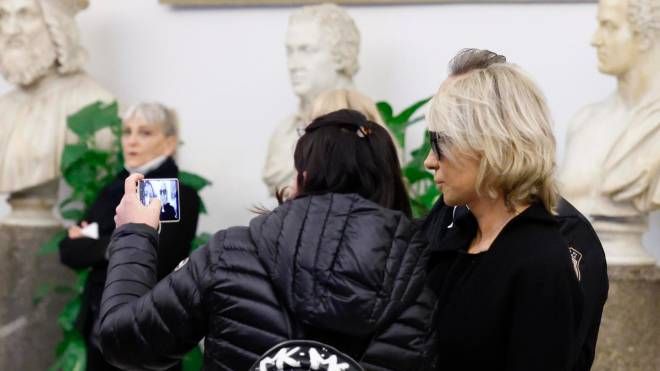 Una donna scatta un selfie con Maria De Filippi alla camera ardente di Costanzo