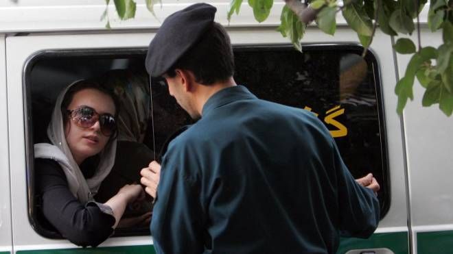 Un poliziotto iraniano parla con una donna arrestata per i suoi vestiti 'inappropriati'