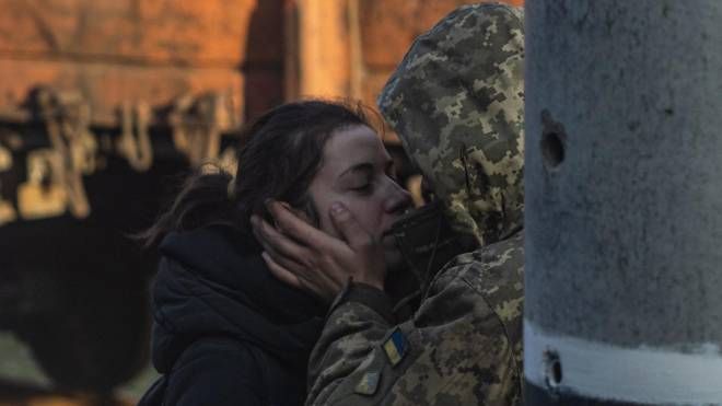 Un soldato ucraino bacia la fidanzata alla stazione (Ansa)