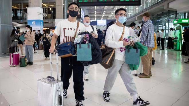 Viaggiatori cinesi in aeroporto dopo la revoca delle restrizioni (Ansa)