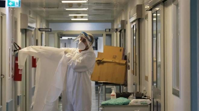Operatore sanitario indossa tuta e mascherina protettive al lavoro in terapia intensiva