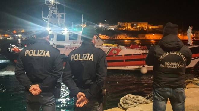 Polizia a Lampedusa davanti alla nave della guardia costiera che ha soccorso i migranti