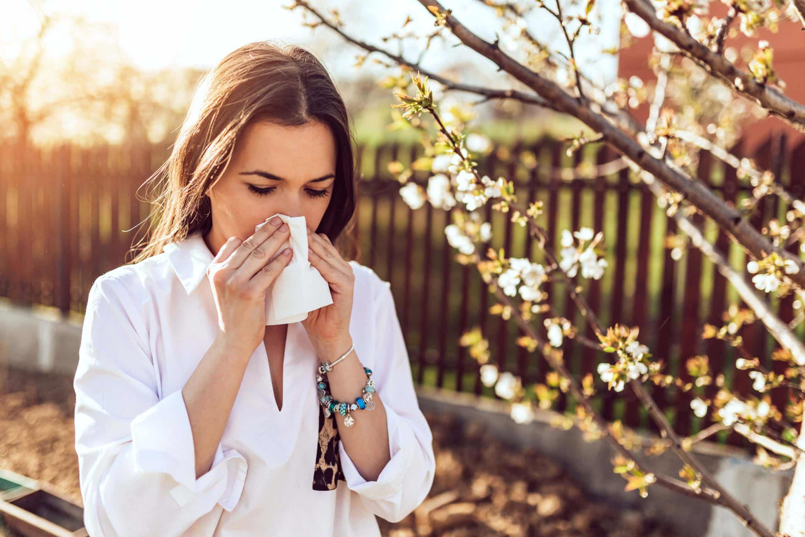 Woman sneezing in the blossoming garden- Crediti ISTOCKPHOTO